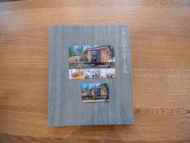 An information book with images of a lodge on a wooden table