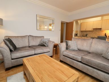 A living room with two gray sofas and a wooden coffee table at Tethera in Bowness-On-Windermere
