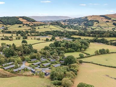 An aerial view of fields and cabins at Barn Owl Lodge in Rhayader