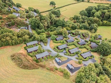 An outdoor area with cabins and greenery at Barn Owl Lodge in Rhayader