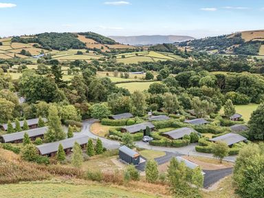 A landscape view of cabins and greenery at Barn Owl Lodge in Rhayader