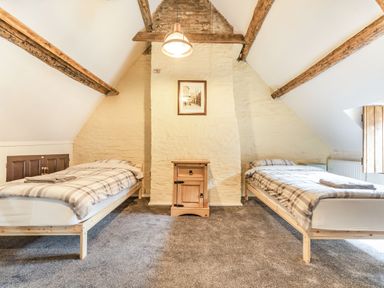 A bedroom with two single beds and a wooden nightstand between them at 48 High Street in Bridlington