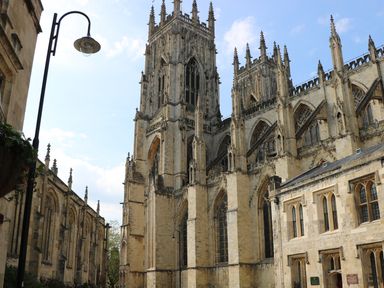 An exterior view of a Gothic cathedral with tall towers and arched windows in Pocklington