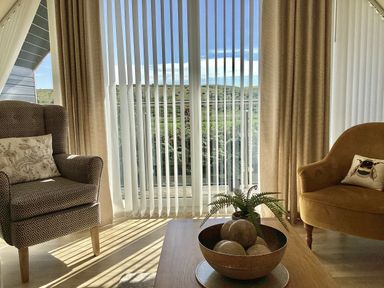 A living room with two armchairs and a table at Larchwood Lodge in Ellon