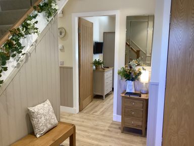 A hallway with a staircase and furniture at Larchwood Lodge in Ellon