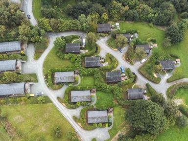 An aerial view of several small houses with driveways surrounded by greenery and trees at Sunny View in Rhayader