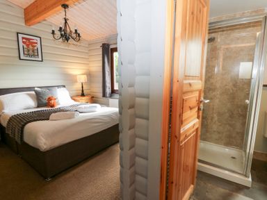 A bedroom with a bed and an adjoining shower at Sunny View in Rhayader