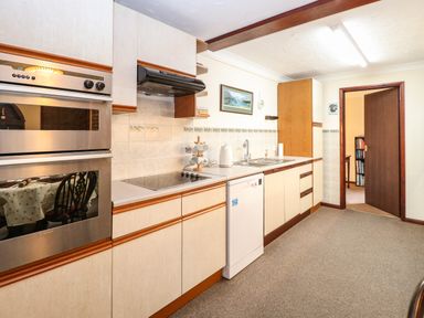 A kitchen with cabinets oven stovetop dishwasher and sink at Walnut Tree Cottage in Catfield