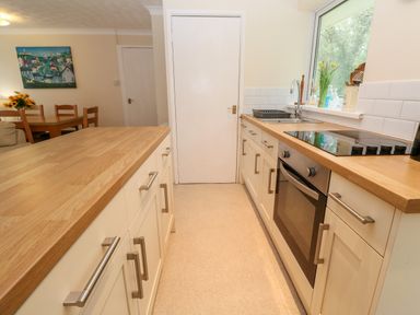 A kitchen with wooden countertops white cabinets and a built-in oven at 17 River Banks in Liskeard
