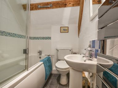 A bathroom with a bathtub shower combination toilet and sink at Teign Cottage in Shaldon