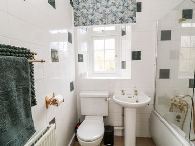 A bathroom with a toilet sink towel rack and bathtub near a window at The Vale in Ashwater
