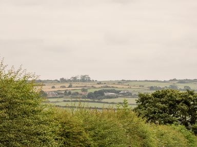 A countryside landscape with fields trees and farm buildings at Shipswheel Cottage at Broadings Farm Whitby
