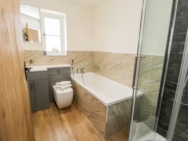 A bathroom with a bathtub toilet sink and shower enclosure at Stag Cottage at Broadings Farm Whitby