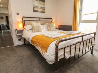 A bedroom with a metal bed frame and two bedside lamps at Box Tree Escapes in Kirkby Lonsdale