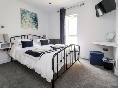 A bedroom with a double bed TV window and vanity area at Box Tree Escapes Wennington near Kirkby Lonsdale
