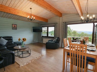 A living room with a sofa and dining table at Mountain View in Rhayader