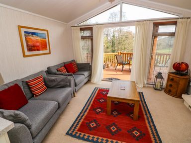 A living room with two grey sofas and a wooden coffee table on a red patterned rug at Jules @ 79 in Stepaside