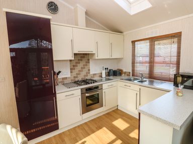A kitchen with white cabinets a stainless steel oven a black refrigerator a window with wooden blinds and a countertop at Jules @ 79 in Stepaside