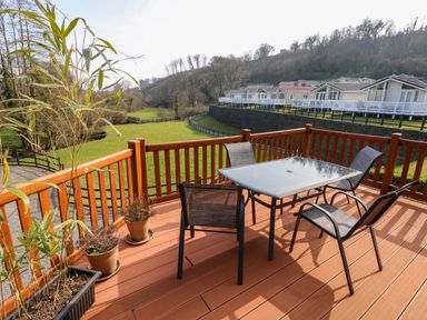 A balcony with table and four chairs overlooking a grassy area and row of houses at Jules @ 79 in Stepaside