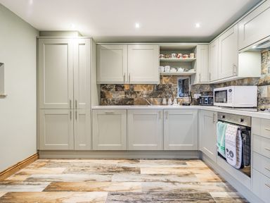 A kitchen with cabinets appliances and a patterned tile backsplash at Meadowsweet in Goathland