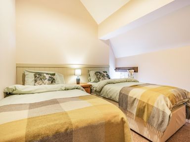 A bedroom with two single beds a nightstand and a lamp at Meadowsweet in Goathland