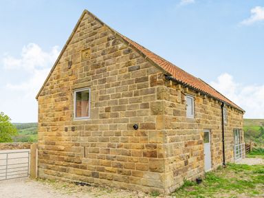 A stone building with small windows and a tiled roof in a rural area at Meadowsweet in Goathland