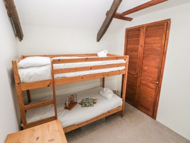 A bedroom with a wooden bunk bed and a wooden cabinet at Pant y FFynnon in St Davids
