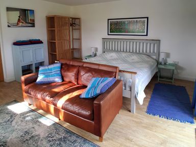 A bedroom with a bed, sofa and wardrobe at Buttercups at Midway Kington