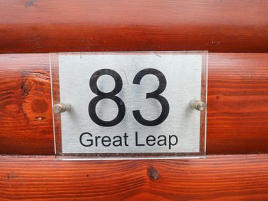 A house number sign 83 on a wooden wall at Great Leap in Louth