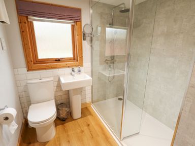A bathroom with a toilet sink shower and window with wooden frame at Great Leap in Louth