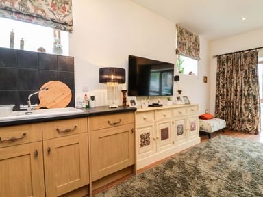 A kitchen with a sink and television at The Coach House, The Grove in Combe Martin