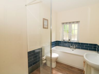 A bathroom with a bathtub a toilet a sink and a window at Glyn Yr Efail in Moylegrove nr Newport and Cardigan