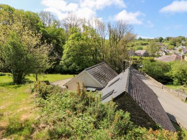 A rural scene with two houses near a road surrounded by trees and greenery at Glyn Yr Efail in Moylegrove nr Newport and Cardigan