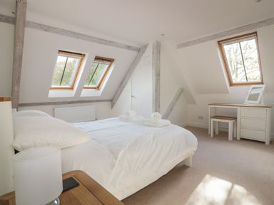 A bedroom with a bed table lamp and dressing table at Stores & Supplies in Bodmin