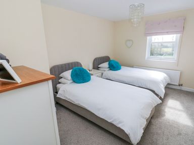 A bedroom with twin beds and a window at Mountain Farm in Broad Haven