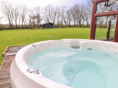 A hot tub with a view of the garden at Mountain Farm in Broad Haven