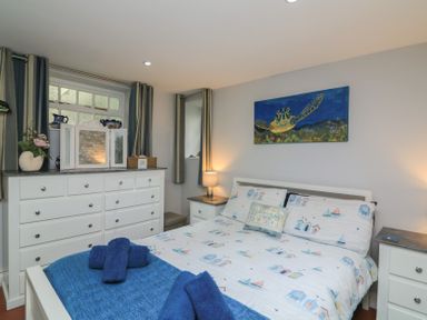 A bedroom with a bed and dresser at Hidden Treasure in Brixham