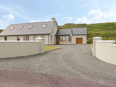 A detached house with a gravel driveway and cream boundary walls at Dooneen near Castletownshend County Cork