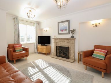A living room with a television and fireplace at 5 Styleman Road, Hunstanton