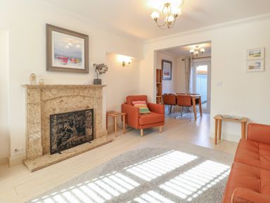 A living room with a fireplace and armchairs at 5 Styleman Road in Hunstanton