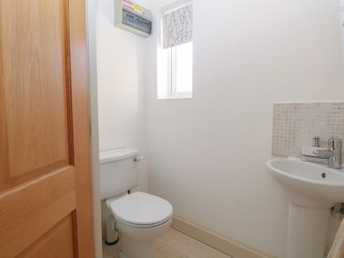 A bathroom with a toilet and sink at 5 Styleman Road, Hunstanton