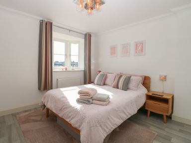 A bedroom with a bed and curtains at 5 Styleman Road in Hunstanton