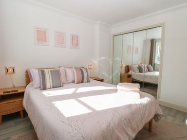 A bedroom with a bed and mirrored wardrobe at 5 Styleman Road, Hunstanton