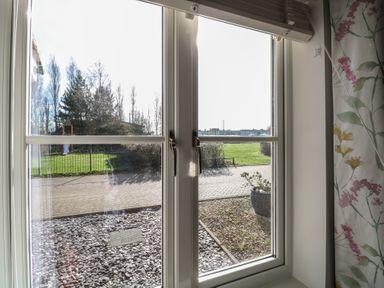 A window view of a garden and pathway at 5 Styleman Road in Hunstanton