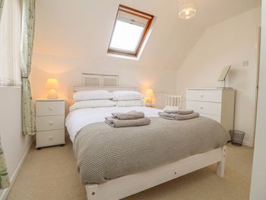 A bedroom with a double bed two bedside tables with lamps and a skylight window at Y Bwthyn Newport Pembrokeshire