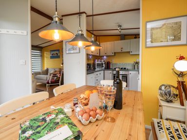 A kitchen and dining area with a wooden table set with eggs and glasses at 4 Country View Park in Graveney near Seasalter