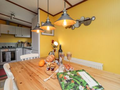 A dining table with food and drinks in a kitchen with yellow walls at 4 Country View Park Graveney near Seasalter