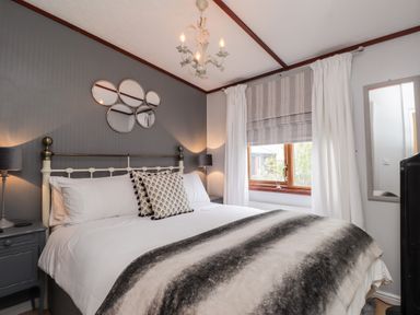 A bedroom with a bed a window and a mirror at 4 Country View Park in Graveney near Seasalter