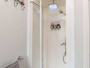 A shower area with rainfall showerhead and wall-mounted dispensers at 4 Country View Park Graveney near Seasalter