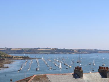 A view of numerous sailboats on water with a shoreline and rooftops in the foreground at The Water House in Falmouth